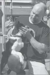  ??  ?? Kevin Gould pets one of the shelter animals present at the Swift Current SPCA Radiothon location on Market Square, Aug. 28. Gould is a Vancouver resident who was back in his home town to visit his parents.