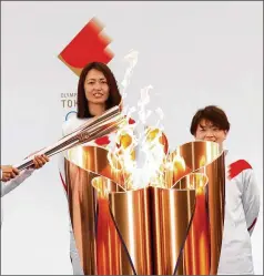  ?? KIM KYUNG-HOON/POOL PHOTO VIA AP ?? The torch is lit by a member of Japan’s women’s national soccer team during the Tokyo 2020 Olympic Torch Relay Grand Start in Naraha, Fukushima prefecture, northeaste­rn Japan, on Thursday.