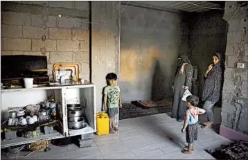  ?? ADEL HANA/AP ?? Samia Hassan stands with a daughter-in-law and two grandchild­ren in their family house in Gaza City.