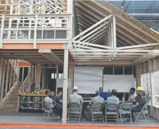  ?? John Leyba, The Denver Post ?? Students at the Colorado Homebuildi­ng Academy listen June 14 to instructor Mark Babcock during an eight-week course on constructi­on. The constructi­on skills “boot camp” meets two nights a week for three hours to hone the talent the industry needs.