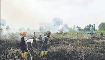  ??  ?? Volunteers from Naim extinguish the fire behind ILP Miri.