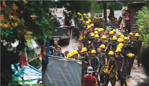  ?? AFP ?? Rescue personnel arrive at Tham Luang cave at Khun Nam Nang Non Forest Park in the Mae Sai district, yesterday. Thai rescuers vowed to take a ‘no risk’ approach to freeing 12 boys and their football coach from a flooded cave, as fresh video emerged on Wednesday showing the team in good spirits following their astonishin­g discovery nine days after going missing.