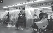  ??  ?? 2. Customers are separated by plastic sheeting as a barber shop in Las Vegas, Nevada, reopens on May 9. JOHN LOCHER / AP