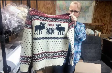  ?? AP ?? Debbie McDermott of East Jordan, Mich., shows the back of a Ralph Lauren sweater that was made using a yarn line made by her company, Stonehedge Fiber Mill.