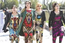  ??  ?? A PICTURE taken on March 19 shows Tajik women wearing the Atlas and other traditiona­l dresses celebratin­g the spring Nowruz festival in Dushanbe. Clothing factories in Tajikistan are churning out brightly coloured national dresses amid a surge in...