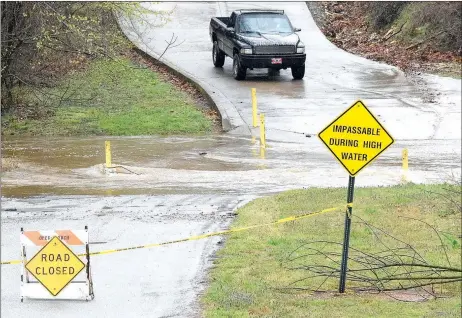  ?? Westside Eagle Observer/MIKE ECKELS ?? A pickup waits at the base of Grant Avenue in Decatur on March 27 as floodwater closed the low-water bridge across Columbia Hollow Creek. Residents of Grant Springs Apartments were stranded for much of the day until the floodwater receded enough that...