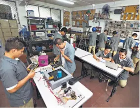  ??  ?? Trabajo en equipo. Unos 75 alumnos de bachillera­to en Sistemas Eléctricos son los que participan y aprenden todos los días en el taller.