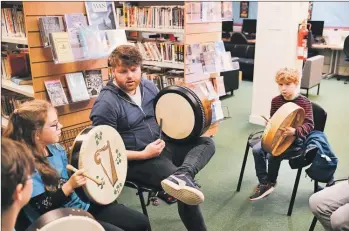  ??  ?? Bodhran and whistles tutor David Foley of the band RURA with young focused participan­ts Charlotte McNeill and Noah Dawton.