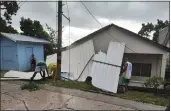  ?? DANIEL PARRA — THE ASSOCIATED PRESS ?? Men pick up a damaged roof in the aftermath of Hurricane Julia in San Andres island, Colombia, on Sunday.