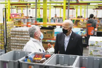  ?? Patrick Semansky / Associated Press ?? President Biden talks with a volunteer at the Houston Food Bank. Tens of thousands of area residents are still without safe water after pipes burst during an unusually cold storm.