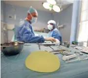  ?? /Reuters ?? Foreign body: A defective silicone gel breast implant lies near surgical instrument­s after being removed from a patient.