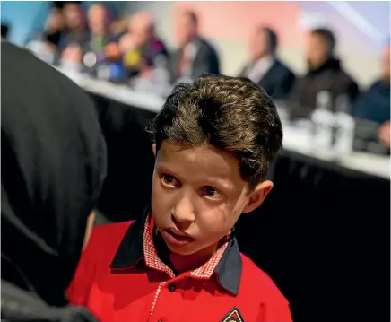  ?? PHOTO: AP ?? Eleven-year-old Syrian Hasan Diab, who spoke and whose image was projected on a screen during a press conference, talks to his mother in The Hague, Netherland­s.