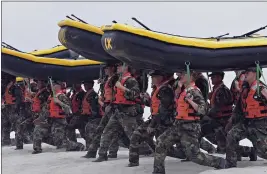  ?? DENIS POROY — THE ASSOCIATED PRESS FILE ?? Navy SEAL trainees carry inflatable boats at the Naval Amphibious Base Coronado in Coronado.