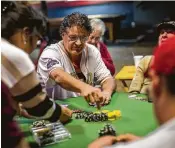  ?? Marie D. De Jesús / Staff photograph­er ?? Chuck Olson, 61, plays Texas Hold ’em with friends and family at B.B. Wolf ’s in Stafford.