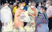  ??  ?? CM Yogi Adityanath distributi­ng ration to people, in Varanasi.