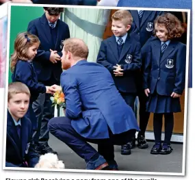  ??  ?? Flower girl: Receiving a posy from one of the pupils