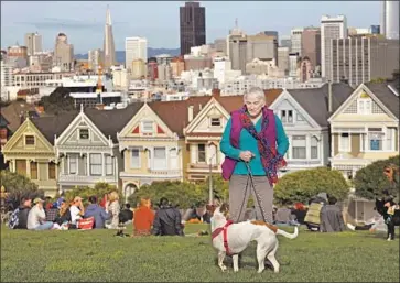  ?? Genaro Molina Los Angeles Times ?? ROBERTA “BERTIE” BROUHARD walks her dog in front of San Francisco’s famed Painted Ladies. The 73-year-old transgende­r activist with “very red Nebraska roots” cast an early ballot for Michael R. Bloomberg.