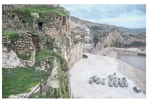  ?? — AFP ?? Sign of the end: Trucks are seen on the banks of the Tigris river near Hasankeyf inhabited for 12,000 years.