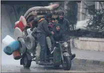  ?? Picture: REUTERS ?? Men ride a tricycle as they flee deeper into the remaining rebel-held areas of Aleppo, Syria.