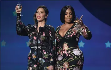  ??  ?? Awards ceremony host Olivia Munn and actress Niecey Nash lead the audience in a toast.