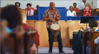  ?? For video of the Stewart Memorial service, visit thespec.com ?? Left: Walter Maclean plays a djembe as a musical start to an Emancipati­on Day Celebratio­n.