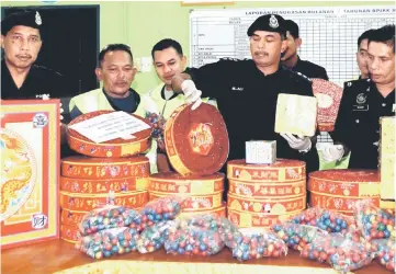  ??  ?? Mohd Ali (second right) and his officers show the seized firecracke­rs and fireworks during the press conference. — Bernama photo