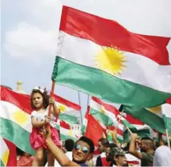  ??  ?? BEIRUT: A man holds a girl waving a Kurdish flag as they gather to support next week’s referendum in Iraq, at Martyrs Square in Downtown Beirut. — AP