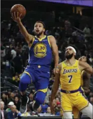  ?? JOHN LOCHER - THE ASSOCIATED PRESS ?? FILE - In this Oct. 10, 2018, file photo, Golden State Warriors guard Stephen Curry shoots next to Los Angeles Lakers center JaVale McGee during the second half of an NBA preseason basketball game, in Las Vegas.