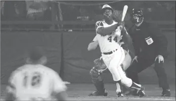  ?? THE ASSOCIATED PRESS FILE – 1974 ?? Hank Aaron of the Atlanta Braves watches the flight of the baseball on his record-breaking 715th career home run.