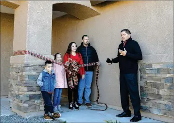  ?? PHOTO BY CESAR NEYOY/BAJO EL SOL ?? MANUEL FIGUEROA (RIGHT), president of the board of directors of Housing America Corp., turns over the keys to their new home to Jose Camarena (second from right) and his family. The home on State Avenue in Somerton was financed through the HOME Investment Partnershi­p Program.