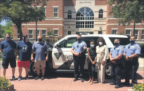  ?? EVAN BRANDT — MEDIANEWS GROUP ?? Members of Lunch is on Us and the Pottstown Police Department catch some sun after getting a pizza delivery.