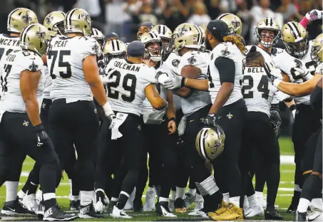  ?? Butch Dill / Associated Press ?? New Orleans players surround Drew Brees after the quarterbac­k broke the NFL’s all-time passing yards record.