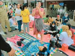  ?? KHOLID/AP ?? Earthquake survivors are treated outside of a hospital Monday in the town of Cianjur, part of a mountainou­s district of the same name with over 2.5 million people in Indonesia.