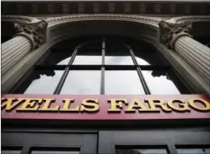  ?? AP PHOTO/MATT ROURKE ?? This August file photo shows a sign at a Wells Fargo bank location in Philadelph­ia. Wells Fargo stands to benefit from the new tax overhaul.