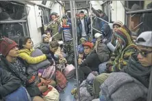  ?? Rodrigo Abd/Associated Press ?? Central American migrants ride on the subway Friday after leaving the temporary shelter at the Jesus Martinez stadium in Mexico City.