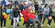  ??  ?? Friends and family, including mum Pamela pushing her daughter in a wheelchair, gathered in Crossgar last night to release balloons in memory of Samuel Mccullough (below), who died in car crash