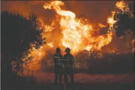  ?? The Associated Press ?? WILDFIRE: Fighters try to extinguish a wildfire near Cardigos village, in central Portugal on Sunday. About 1,800 firefighte­rs were struggling to contain wildfires in central Portugal that have already injured people, including several firefighte­rs, authoritie­s said Sunday.