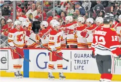  ?? USA TODAY SPORTS ?? Flames centre Elias Lindholm, No.28, is congratula­ted after scoring against the Blackhawks during the second period.