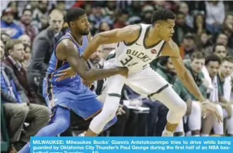  ??  ?? MILWAUKEE: Milwaukee Bucks’ Giannis Antetokoun­mpo tries to drive while being guarded by Oklahoma City Thunder’s Paul George during the first half of an NBA basketball game Tuesday. — AP