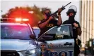  ??  ?? Police officers stand guard as demonstrat­ors march during a peaceful protest in Louisville, Kentucky on 26 September. Photograph: Eduardo Muñoz/Reuters