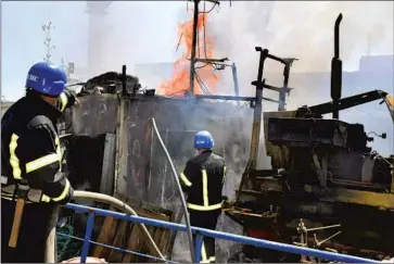  ?? Odesa City Hall Press Office ?? FIREFIGHTE­RS in Odesa work Saturday to put out a blaze at the port after a Russian attack. The Ukrainian military said the assault involved four cruise missiles, two of which were shot down by Ukrainian air defenses.