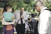  ??  ?? PASTOR Roger Jimenez, right, prays with Oliver Gonzalez, center, and his wife Melody, holding a child.