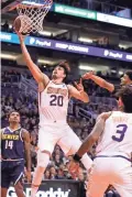  ??  ?? The Suns' Dario Saric goes up for a layup in the first quarter against the Nuggets at Talking Stick Resort Arena in Phoenix on Monday night.