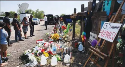  ?? TAYFUN COSKUN / GETTY IMAGES ?? People leave flowers, candles and water at a memorial event on June 29, 2022 in San Antonio, Texas, where 53 migrants died after being trapped in a tractor-trailer.