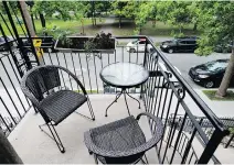  ??  ?? The St-Henri triplex has two balconies, one of which looks over a park adorned with flower beds and a fountain.