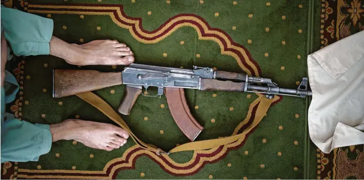  ?? Fotos: Felipe Dana und Muhammad Farooq/AP, dpa ?? Und immer ist die Waffe dabei: Ein Taliban‰Kämpfer hat seine Kalaschnik­ow für das Freitagsge­bet in einer Moschee in Kabul abgelegt.