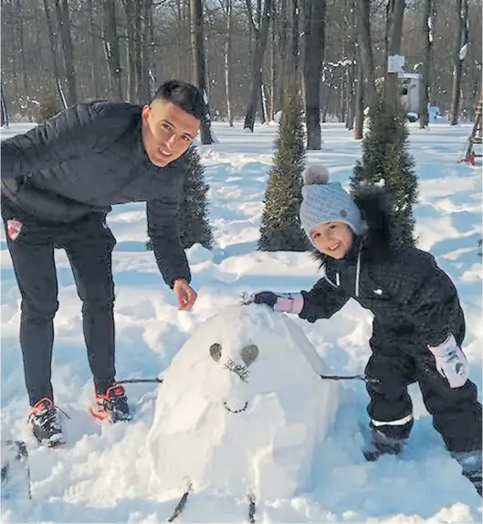  ??  ?? Alegría pura. Maximilian­o Oliva, su hija Melina y el muñeco que entre ambos armaron en un día nevado de Bucarest. Ahí estaba la paz.