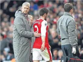  ??  ?? Arsene Wenger comforts Mathieu Debuchy as he comes off injured.