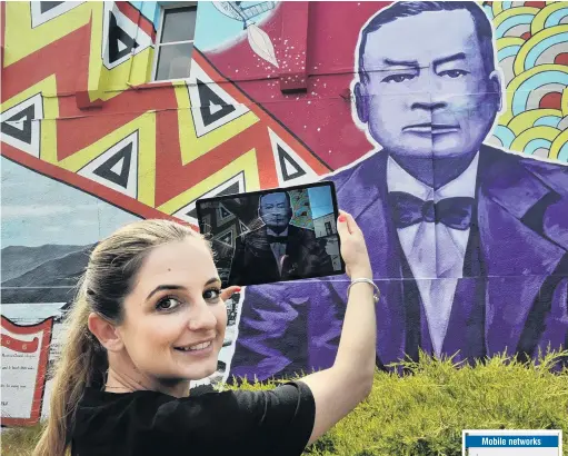  ?? PHOTO: GREGOR RICHARDSON ?? Connecting past and present . . . Spark corporate relations lead partner Cassie Arauzo displays the capabiliti­es of 5G on a mural on the side of the Crown Hotel in Dunedin.