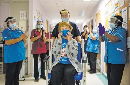  ?? Jacob King The Associated Press ?? Margaret Keenan, 90, receives applause Tuesday at University Hospital in Coventry, England, after becoming the first patient in the U.K. to receive the Pfizer-biontech COVID-19 vaccine. The U.K. is the first Western country to deliver a broadly tested vaccine to the public.